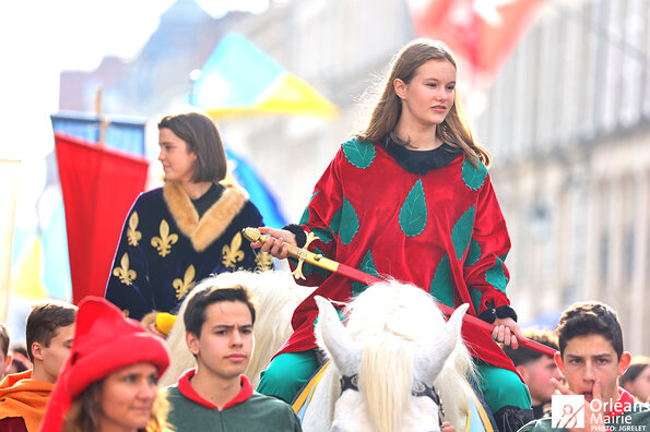 Défilé des Fêtes de Jeanne d'Arc à Orléans : la jeune fille figurant Jeanne d'Arc défilant à cheval dans les rues de la ville