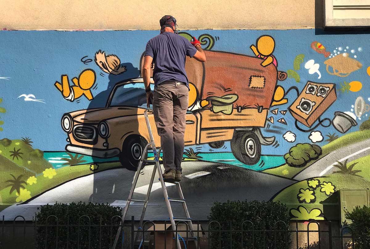 L'artiste JACE - le mur Orléans L'artiste Jace, sur un escabeau, peint une fresque à la bombe le mur rue Henri Roy à Orléans